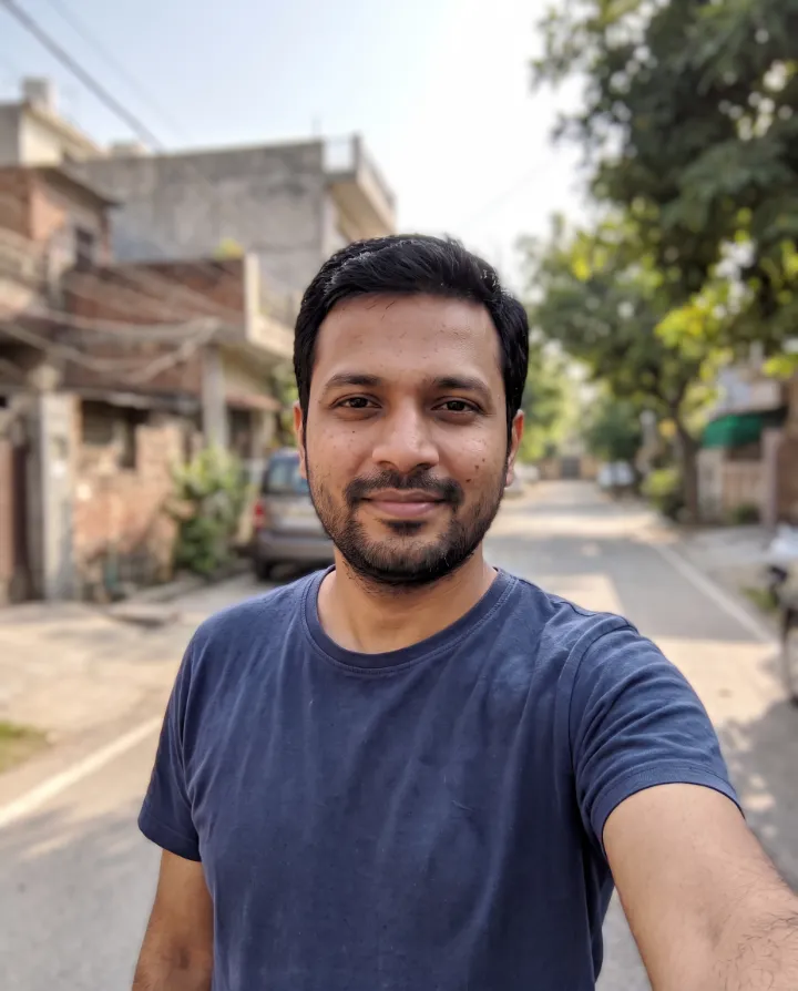 The same selfie with the street behind the man strongly blurred and his face kept sharp